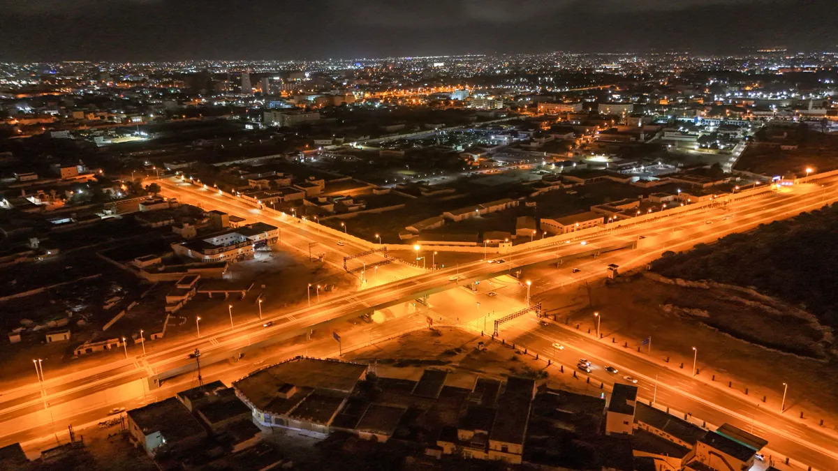 Lit highway interchange in an African city at night